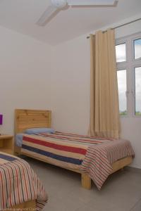 特鲁欧克比赫斯Villa Alexis - Location de vacances à Trou aux Biches的一间卧室设有两张床和窗户。