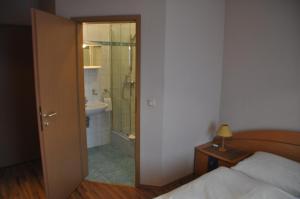 施瓦尔巴赫新时代酒店的一间卧室配有一张床,浴室设有淋浴。