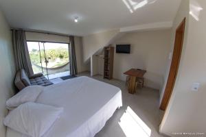 普腊亚罗萨Recanto Sol&Mar的卧室设有一张白色大床和一扇窗户。