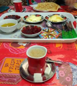 Zaouia ech CheïkhHotel Imilchil的餐桌,茶几,咖啡和一盘食物