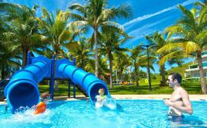 美奈海联海滩高尔夫度假酒店的男人和两个孩子在游泳池里玩耍