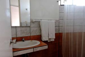 皮斯科米拉玛旅舍的浴室配有盥洗盆、镜子和毛巾
