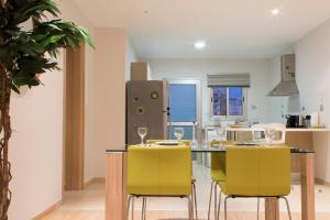 利马索尔Eden Beach Apartment 207的厨房配有带黄色椅子的餐桌