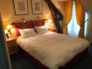 Yvoy-le-MarronLogis Hôtel Auberge du Cheval Blanc的卧室配有一张白色大床和两盏灯。