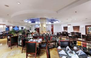 三宝垄格朗德坎迪酒店的一间带桌椅的餐厅和一间酒吧