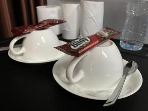 呵叻R2公寓服务宾馆的黑桌上两个白杯和勺子