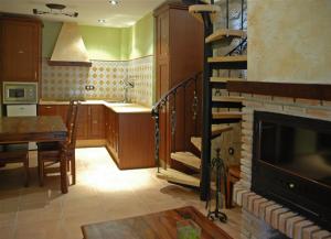 巴埃萨La Azacaya的厨房设有带壁炉和桌子的客厅。