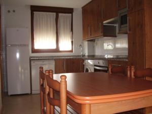 桑提亚纳德玛La Pergola的厨房配有木桌和白色冰箱。