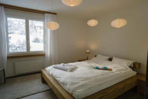 伦策海德Seestrasse 1 (292Ap)的一间卧室配有一张带白色床单的床和一扇窗户。