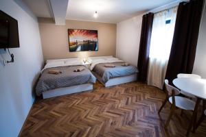 卢布尔雅那New rooms & apartments in Ljubljana的配有桌子和用餐室的客房内的两张床