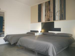 阿夸维瓦德莱丰蒂B&B Via Roma 15的一间卧室设有两张床和一幅画作墙