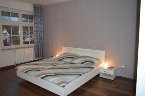 埃森Ferienwohnung "Haus 10"的一间卧室配有一张大床,两盏灯