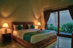沙努尔花园别墅酒店的一间卧室设有一张大床和一个大窗户