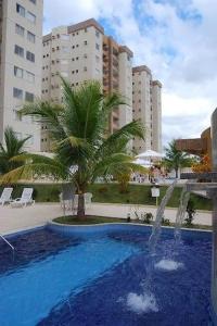 卡达斯诺瓦斯Excelente apartamento de 02 quartos no Privê das Thermas II em Caldas Novas的一座棕榈树游泳池和一个喷泉