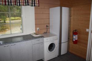 VarpaisjärviKuusitorppa的厨房配有冰箱和洗衣机。