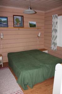 VarpaisjärviKuusitorppa的一间位于客房内的带绿床的卧室