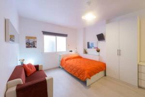 巴塞罗那马贝尔公寓酒店的一间卧室配有橙色的床和沙发
