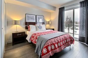 博普雷INITIAL - OLYMPIQUE - Mont-Sainte-Anne的一间卧室设有一张床和一个大窗户