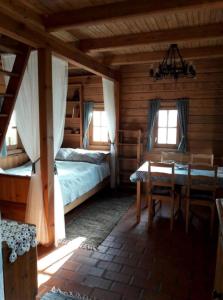 SzattaKiskemence Vendégház Szatta的小屋内设有一间带两张床和一张桌子的卧室