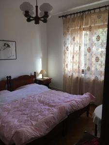 洛雷茨卡APP Rojko的一间卧室配有一张带粉色毯子的床和窗户。