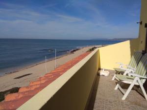 波瓦-迪瓦尔津Largo do cruzeiro的一个带两把椅子的阳台和海滩