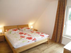 于克里茨Kapitänsresidenz - Haus direkt am Wasser的一间卧室,床上有红色的鲜花