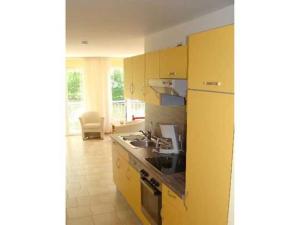 黑灵斯多夫Villa Sylvia的黄色的厨房设有水槽和炉灶
