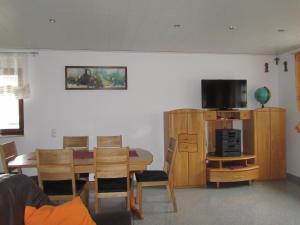 奥伯基希Ferienhaus Wunsch的客厅设有餐桌和电视