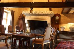 Vollezele斯皮林住宿加早餐旅馆的客厅设有壁炉、桌子和椅子