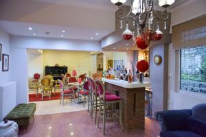 阿姆菲洛希亚Oscar Hotel的厨房以及带粉红色椅子的酒吧的用餐室