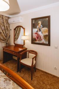 柴可夫斯基Отель Чайковский的客房设有书桌、镜子和椅子。