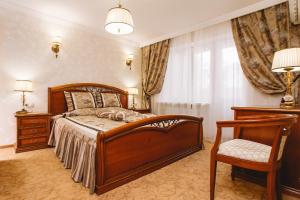 柴可夫斯基Отель Чайковский的一间卧室配有一张木床和一把椅子