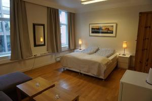 奥勒松Kirkegata 4的一间卧室配有一张床、两盏灯和一张沙发。