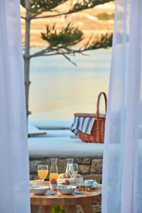 奥诺斯米科诺斯波浪海滨公寓式酒店的餐桌,带食物盘和橙汁杯