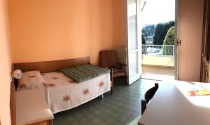 阿尔梅诺玛丽亚坎蒂达灵性中心旅馆的一间卧室设有一张床和一个阳台