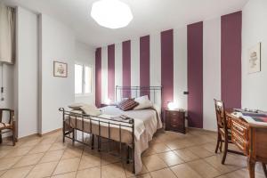 博洛尼亚AbitaRoom Wine Mini-Flat的一间卧室配有一张床和条纹墙