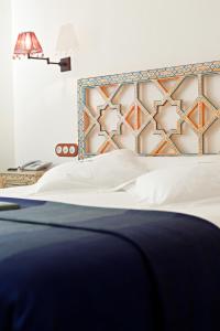 塞维利亚塞维利亚国王寝宫酒店的一间卧室配有一张蓝色和橙色床头板的床