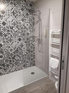 蒙彼利埃罗亚酒店的带淋浴的浴室以及黑白墙纸。