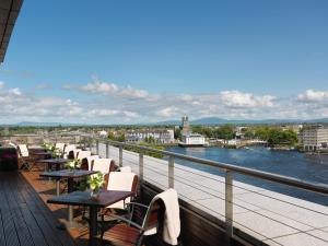 利默里克利默里克斯坦恩德酒店的俯瞰河流的阳台上一排桌椅
