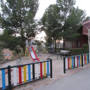 阿尔巴拉辛Camping-Bungalows Ciudad de Albarracín的一个带红色滑梯和秋千的游乐场