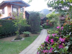 卢米亚Pousada Arte de Viver的一座花园,在房子前方种有粉红色的花朵