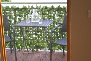 魏玛Ferienwohnung Alexander的阳台上配有一张桌子、两把椅子和一个玻璃瓶