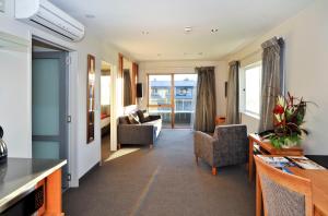 罗托鲁瓦围邑湖滨spa度假酒店的客厅配有两把椅子和一张沙发