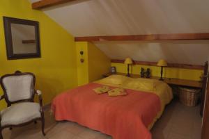 贝莱金圣让酒店的一间卧室配有一张带红色毯子和椅子的床