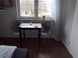 ModautalLandhotel Alte Mühle的窗户间里的一张桌子和两把椅子