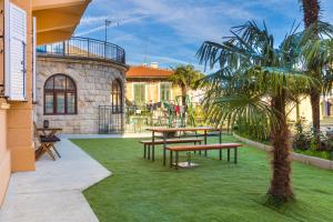 奥帕提亚Apartment Fiorentina的一个带野餐桌和棕榈树的庭院