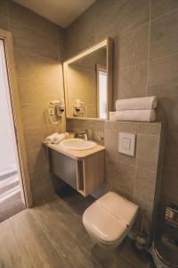 萨拉热窝诺瓦本特巴萨酒店的一间带卫生间、水槽和镜子的浴室