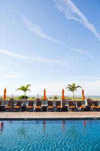 五月岬郡海洋俱乐部酒店的一个带椅子和棕榈树的度假村游泳池