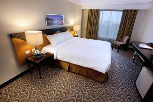 宿务伊丽莎白酒店 的酒店客房设有一张大床和一张书桌。
