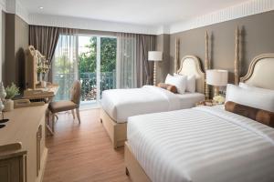 曼谷Casa Vimaya Riverside的酒店客房配有两张床和一张书桌